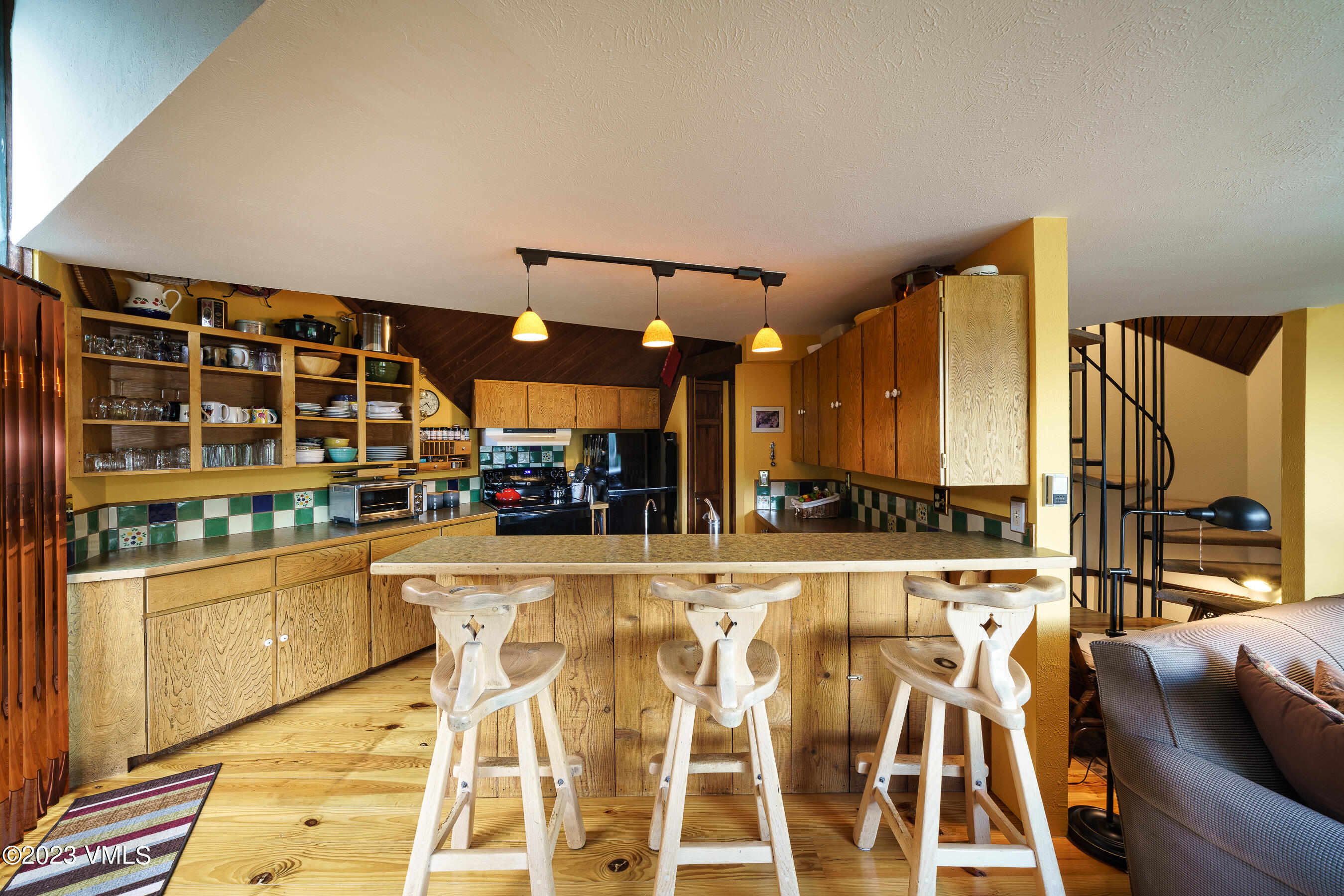 1400 Lions Ridge Loop, Unit A2 Vail, CO 81657 - Photo 9 of 38 a kitchen with stainless steel appliances kitchen island granite countertop a refrigerator and cabinets