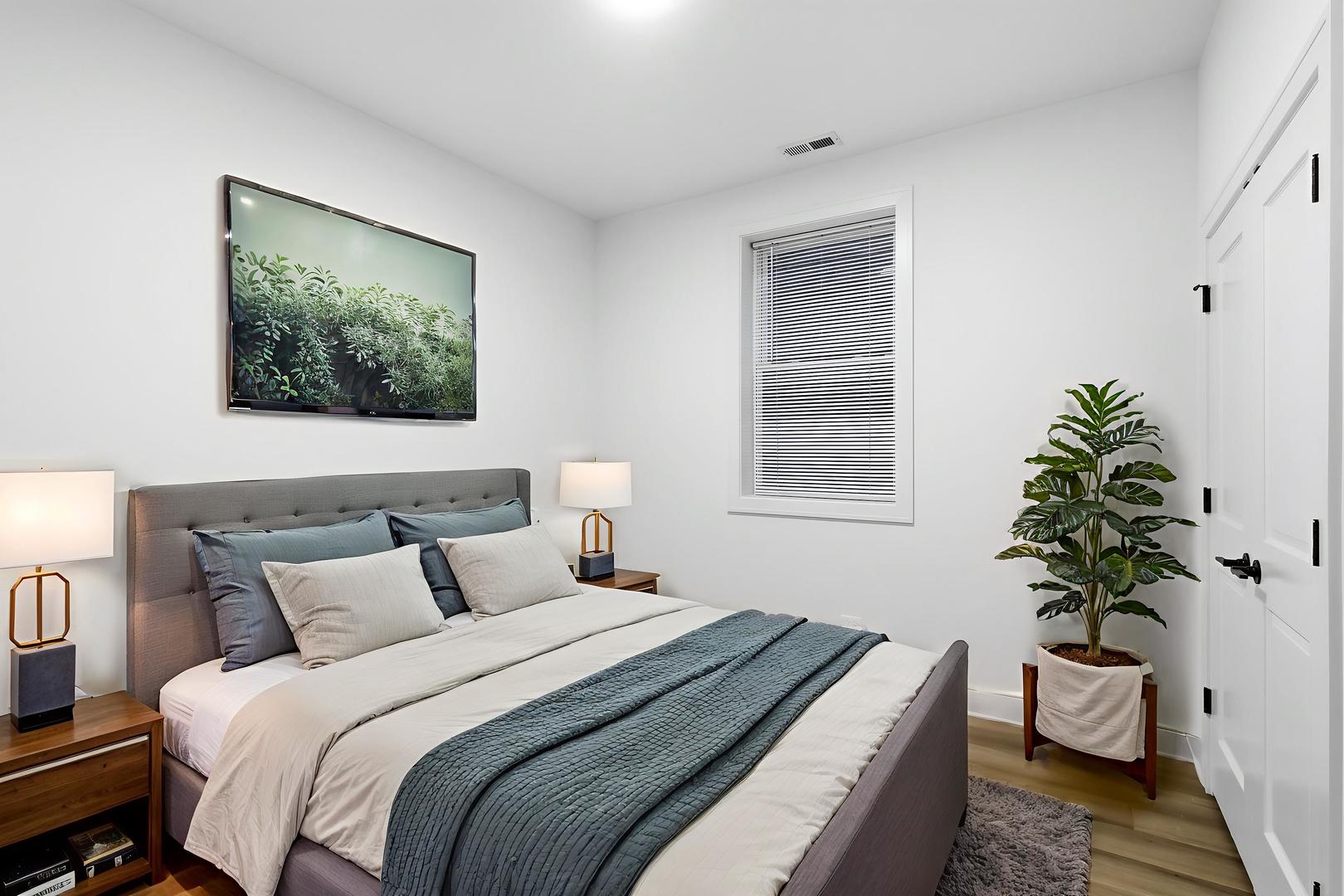 4739 South Indiana Avenue Chicago, IL 60615 - Photo 21 of 38 a bedroom with a large bed and a potted plant