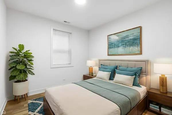 a bedroom with a bed and a potted plant