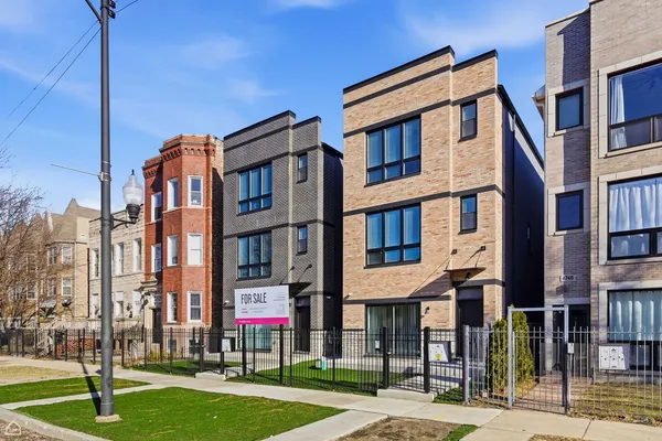 a front view of a residential apartment building with a yard