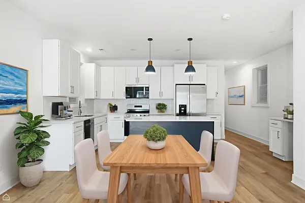 a kitchen with stainless steel appliances granite countertop a stove a kitchen island a stove a table and chairs