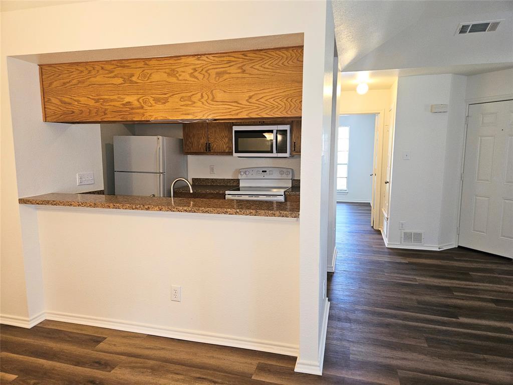 508 East Denton Drive Euless, TX 76039 - Photo 12 of 22 a view of kitchen with stainless steel appliances granite countertop a stove and a wooden floor