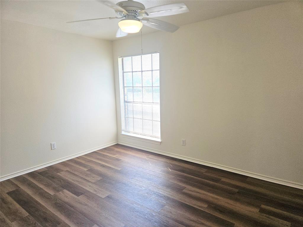 508 East Denton Drive Euless, TX 76039 - Photo 15 of 22 an empty room with wooden floor fan and windows