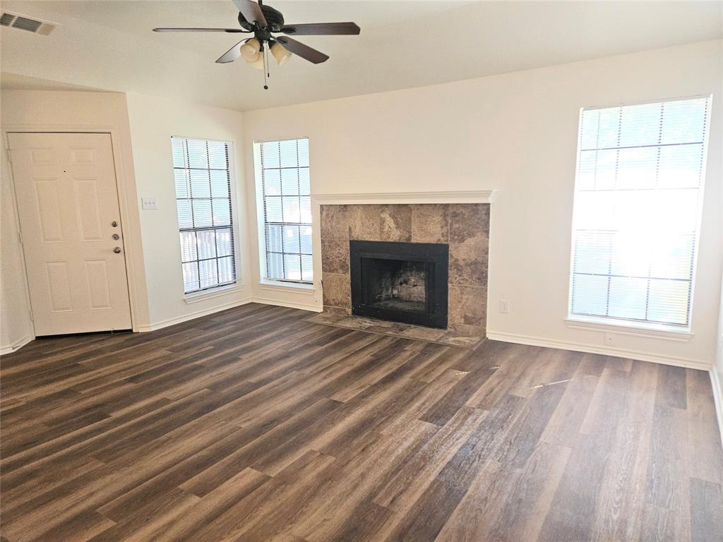 508 East Denton Drive Euless, TX 76039 - Photo 8 of 22 an empty room with wooden floor fireplace and windows