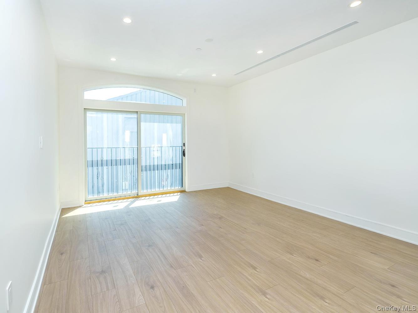 24 Lumber Road, Unit 2 Roslyn, NY 11576 - Photo 10 of 25 a view of an empty room with wooden floor and glass door