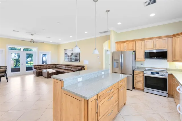 a kitchen with stainless steel appliances granite countertop a stove refrigerator and a sink