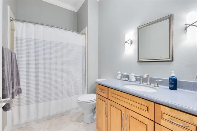 a bathroom with a granite countertop sink mirror vanity and toilet
