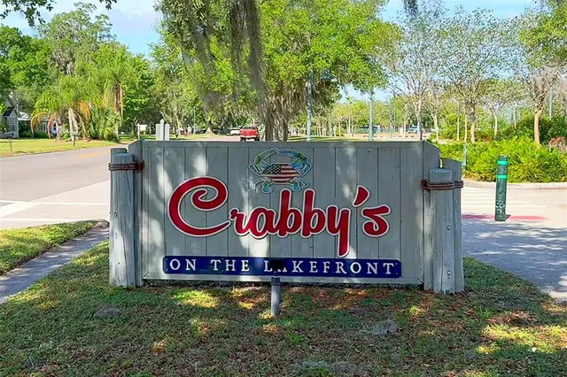 a sign that is on a wooden wall under a tree