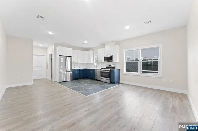 a view of kitchen with wooden floor and electronic appliances