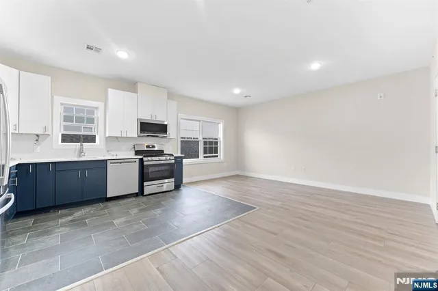 a kitchen with stainless steel appliances a refrigerator sink and microwave