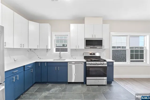 a kitchen with stainless steel appliances a stove a sink and a microwave