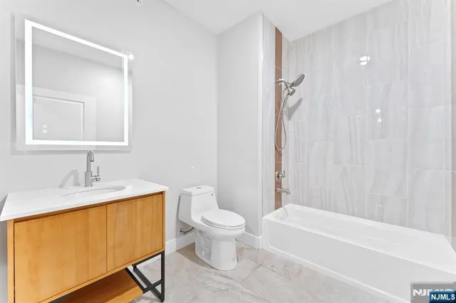 a bathroom with a granite countertop sink toilet and a mirror