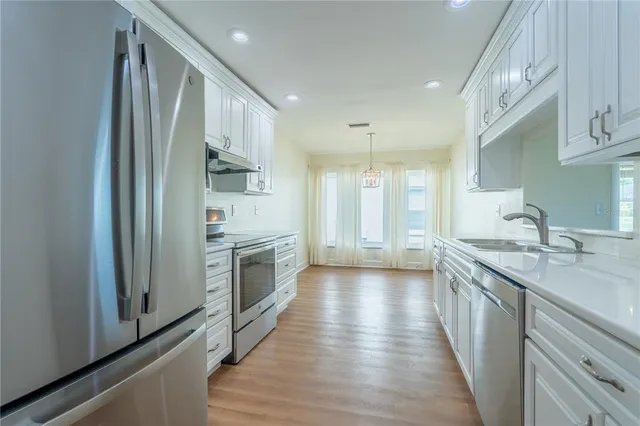 a kitchen with stainless steel appliances granite countertop a sink stove and refrigerator