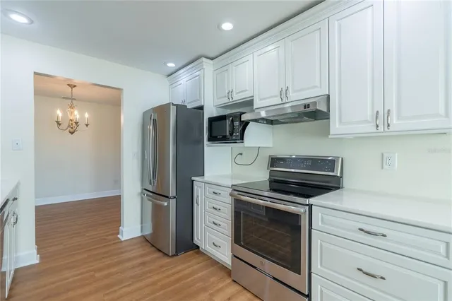 a kitchen with stainless steel appliances white cabinets and a refrigerator