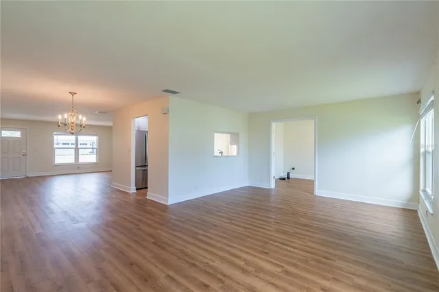 a view of a big room with wooden floor and windows