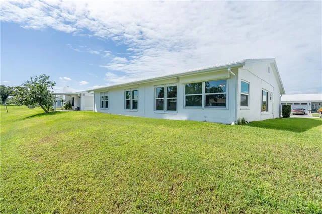 a view of a house with yard and sitting area
