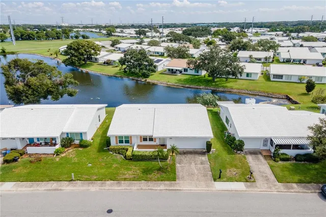 an aerial view of a house with a yard and lake view