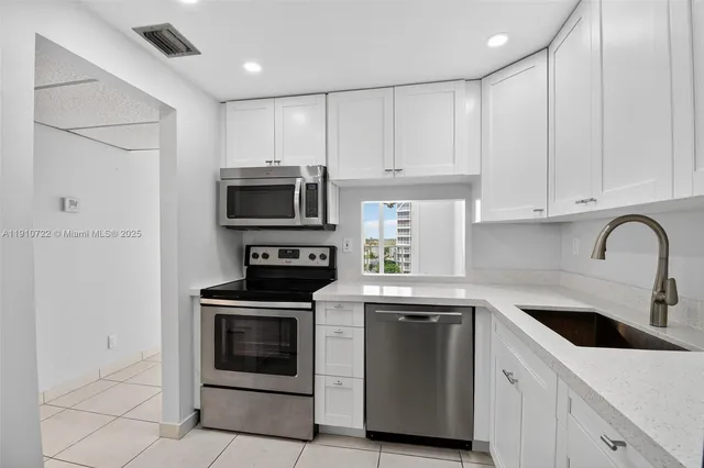 a kitchen with white cabinets and stainless steel appliances