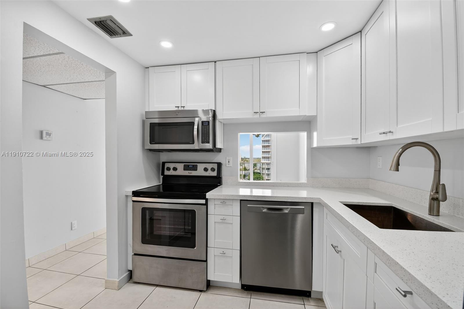 336 North Birch Road, Unit 12B Fort Lauderdale, FL 33304 - Photo 14 of 55 a kitchen with white cabinets and stainless steel appliances