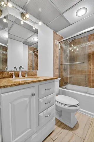 a bathroom with a double vanity sink toilet mirror and shower