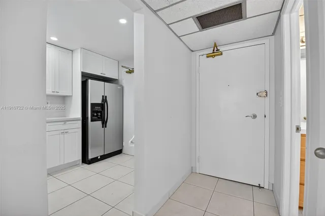 a view of a refrigerator and more cabinets