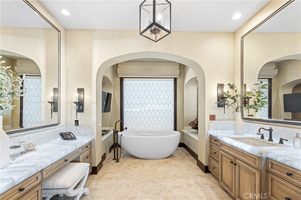 16 Shore Walk Newport Coast, CA 92657 - Photo 28 of 75 a spacious bathroom with a granite countertop tub a double vanity sink and a mirror
