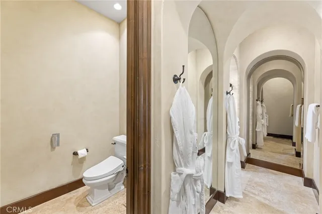 a bathroom with a granite countertop sink vanity mirror and toilet