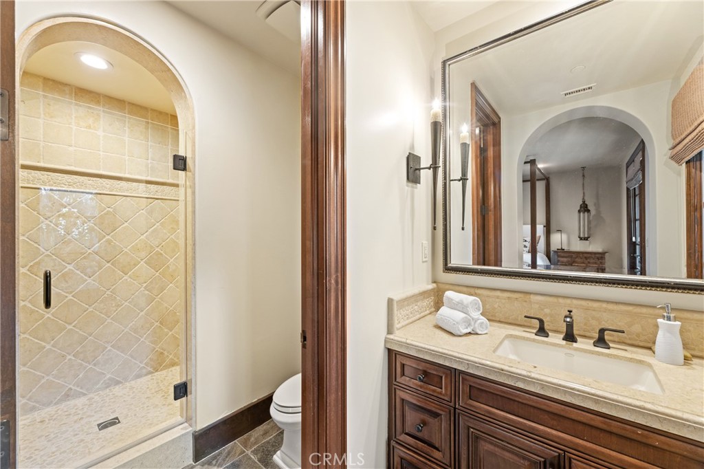 16 Shore Walk Newport Coast, CA 92657 - Photo 53 of 75 a bathroom with a granite countertop sink a mirror and a shower