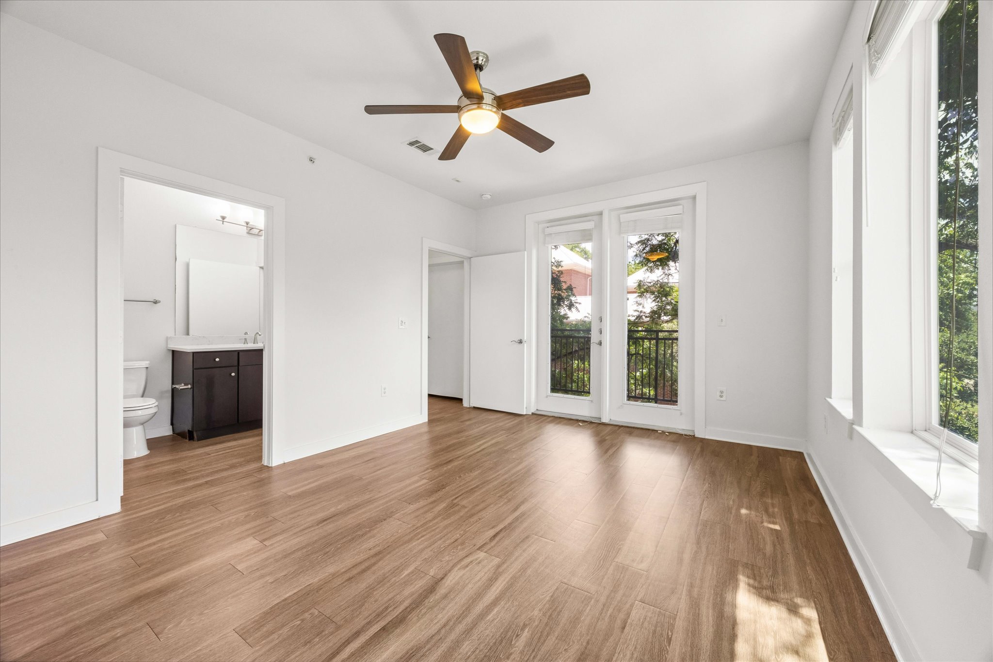1900 Barton Springs Road, Unit 4041 Austin, TX 78704 - Photo 21 of 35 A spacious bedroom features rich wood flooring, balcony access, and ample natural light.