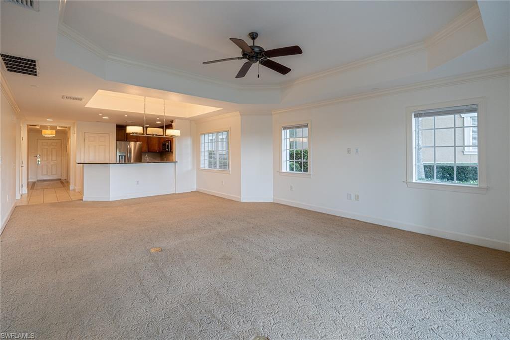 1362 Centre Ct Ridge Drive, Unit 101 Reunion, FL 34747 - Photo 6 of 25 Unfurnished living room featuring crown molding, ceiling fan, light colored carpet, and a raised ceiling