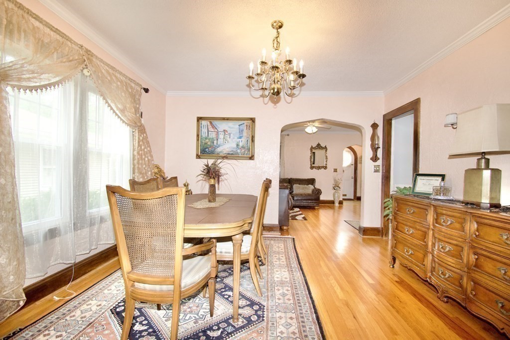 94 Gillette Avenue Springfield, MA 01118 - Photo 15 of 31 a view of a dining room with furniture a chandelier and wooden floor
