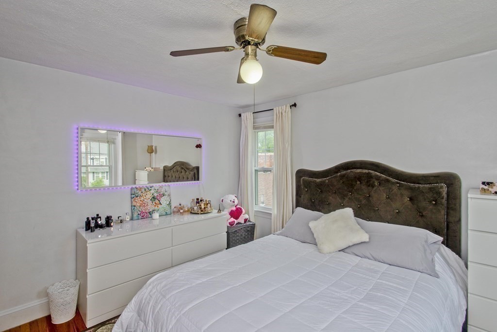 94 Gillette Avenue Springfield, MA 01118 - Photo 22 of 31 a bedroom with a bed potted plant on dresser and a chandelier