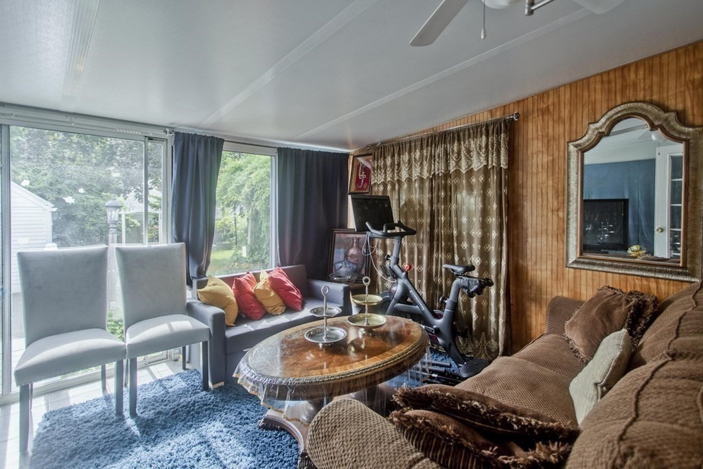 94 Gillette Avenue Springfield, MA 01118 - Photo 29 of 31 a living room with furniture a fireplace and a floor to ceiling window