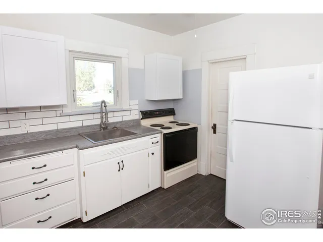 a kitchen with a refrigerator a stove top oven
