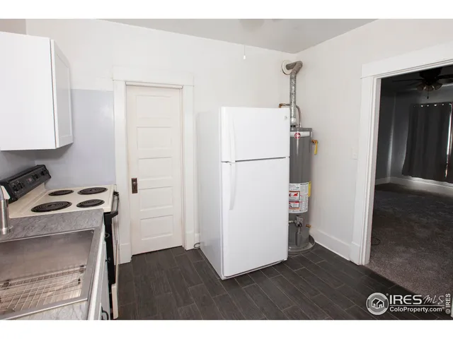 a view of an empty room with wooden floor and closet