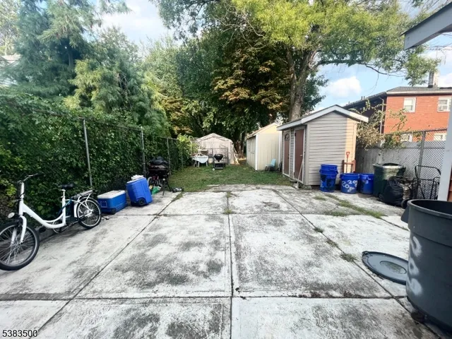 a view of a backyard with table and chairs and a barbeque