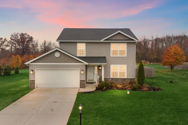 a front view of a house with a yard and garage