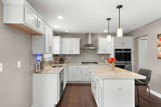a kitchen with a sink a counter space appliances and cabinets