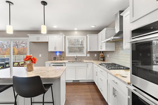 a kitchen with stainless steel appliances granite countertop a sink stove and refrigerator