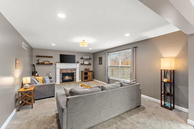 a living room with furniture a fireplace and a flat screen tv
