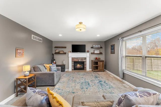 a living room with furniture a fireplace and a flat screen tv