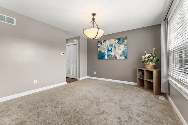 an empty room with windows and fan