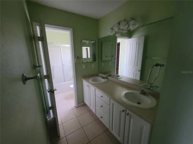 an empty room with wooden floor and a ceiling fan