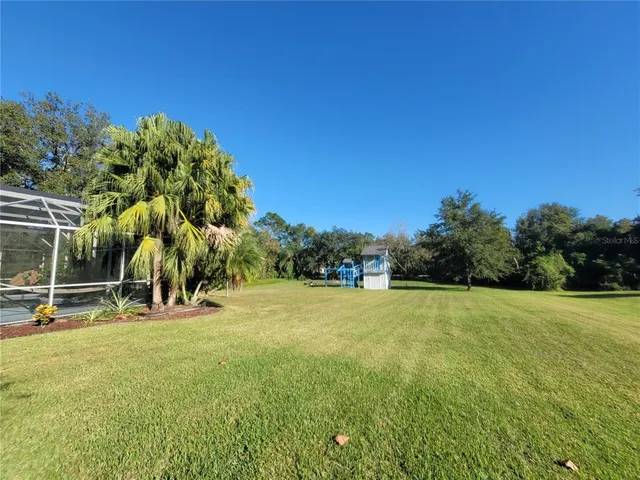 an aerial view of a house with a yard and lake view