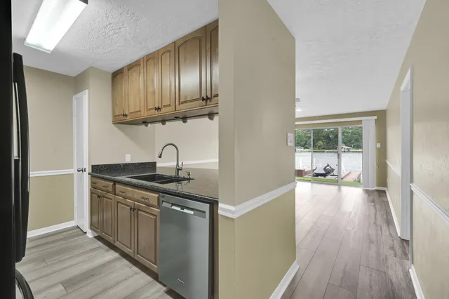 a kitchen with stainless steel appliances granite countertop a sink a stove and wooden floors