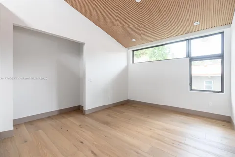 an empty room with windows and closet