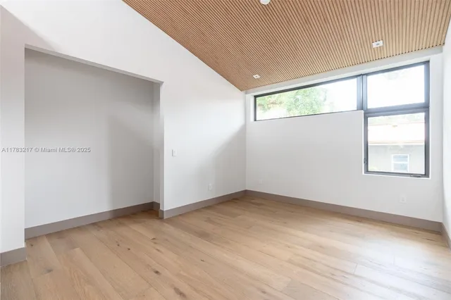 an empty room with windows and closet