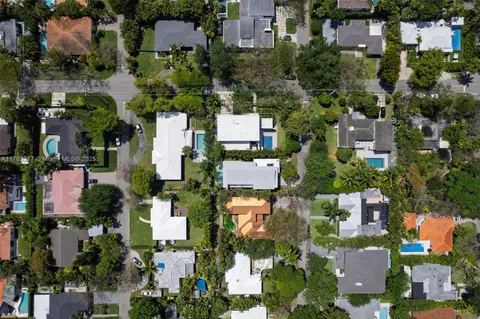 an aerial view of a house with a swimming pool and a yard