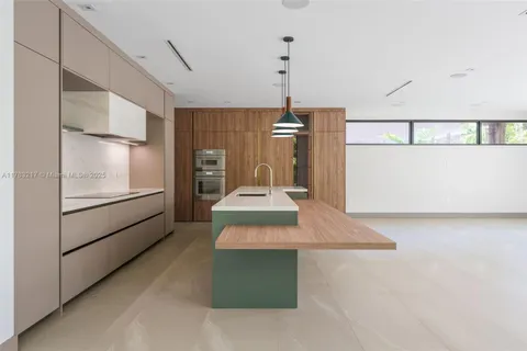 a kitchen with kitchen island a sink stainless steel appliances and cabinets