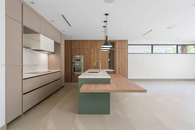 a kitchen with kitchen island a sink stainless steel appliances and cabinets